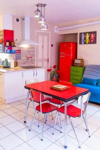 Espaly-Saint-MarcelL'escapade Vintage, garage, Balnéo, 2 SDB, à 5 minutes du Puy的厨房以及带红色桌椅的起居室。