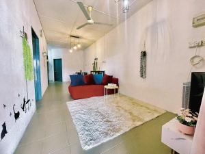 大山脚Cozy33#4pax#Wifi#NearAeonAlma#20minstobatukawan的客厅配有红色沙发和地毯。
