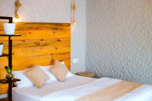 博卡拉The Hideout Villa Pokhara的卧室配有白色的床和木制床头板