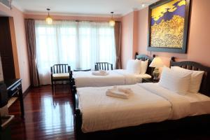 曼谷Siri Heritage Bangkok Hotel的酒店客房,配有两张带毛巾的床