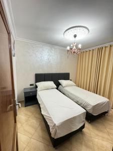 纳祖尔Appart Hotel Excellent的一间卧室配有两张床和吊灯。