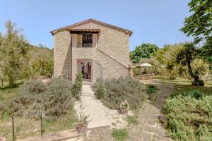 马焦内Agriturismo Il Mulino delle canutole的享有带花园的石屋的外部景色