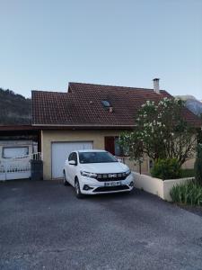 克吕斯Chambre avec vue sur jardin et salle de bain à partager的停在房子前面的白色汽车