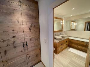 弗利姆斯Elegant apartment in Flims close to Lake Caumasee的一间带两个水槽和木墙的浴室