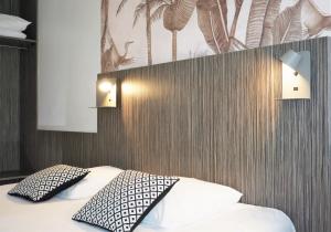 翁德尔The Originals City, Hôtel Le Lodge, Bayonne Nord的一间卧室配有一张带两个枕头的床
