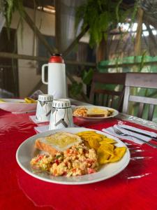 Puerto NariñoMaiku Amazonas-Puerto Nariño的一张桌子,上面有盘子的食物放在红色的桌布上