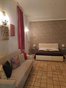 锡拉库扎Appartamento Dammuso Isola Di Ortigia的客厅配有床和沙发