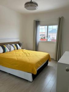 巴亚希贝Mojito&tequila apt. Bayahíbe的一间卧室设有一张黄色的床和窗户