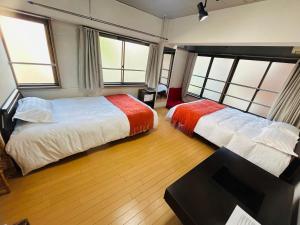 东京Ueno Iriya hostel的带2扇窗户的客房内的2张床