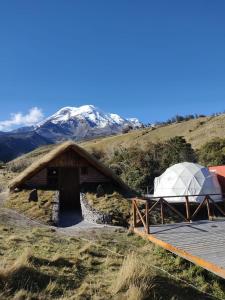 ChimborazoChimborazo Basecamp的一座带圆顶的桥梁和一座山丘上的帐篷