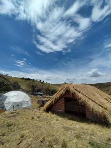 ChimborazoChimborazo Basecamp的帐篷和干草屋顶建筑