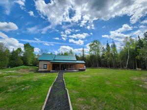 MerrickvilleCottontail Cabin with Hot Tub and wood fired Sauna的田野上带绿色屋顶的小木屋