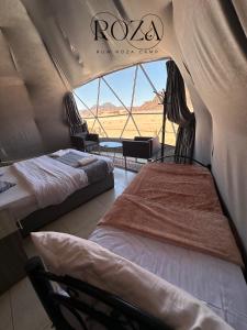 瓦迪拉姆Rum Roza luxury camp的帐篷内的两张床,享有田野美景