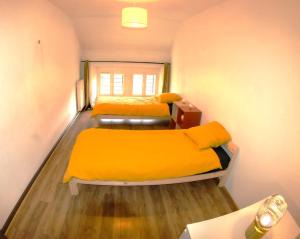 若西耶SUITE dans VILLA MEXICAINE的小客房内的两张床,配有黄色床单