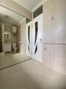 KooperatorЭлитная 2-комнатная квартира в районе Болашак的一间带卫生间和白色门的浴室
