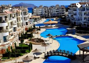 沙姆沙伊赫Sharm Hills Hotel的享有蓝色泳池的度假村的空中景致