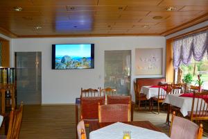 Zorge坎赞托兰德酒店的一间墙上配有电视的用餐室
