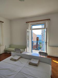 尼亚卢卡弗兰科宾馆的白色的卧室设有一张大床和一个大窗户