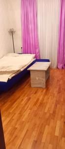 巴库NIZAMI Street flat的一间卧室配有一张床,铺有木地板