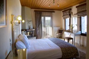 尼奥楚里翁Χρυσοπελεια - Chrisopeleia Lake View的酒店客房配有一张床、一张书桌和一张书桌。