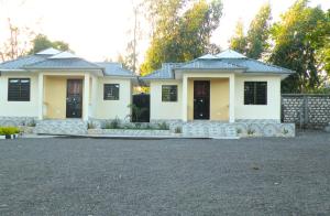 姆特瓦帕Wajiji Homes的白色的房子,有黑窗和车道