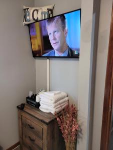 安克雷奇Compact But Cozy Too的墙上的电视,带毛巾的梳妆台
