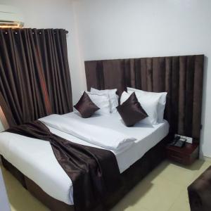 莱基Admiralty Hotel的一张带白色床单和棕色枕头的床