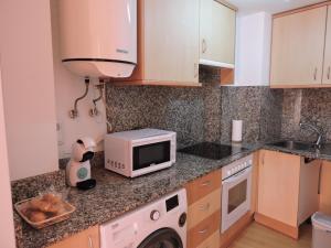 卡拉塔尤德Apartamento casco histórico de Calatayud的厨房配有微波炉和洗衣机。