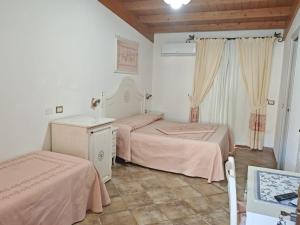 多尔加利Hotel Barbagia的一间卧室配有两张带粉红色床单的床