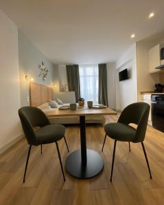 尼斯App-Art的客厅配有桌子和两把椅子