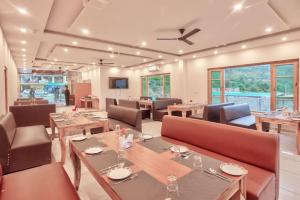 ShamshiVivaan stays的餐厅设有木桌、椅子和窗户。
