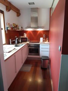 奥尼亚特CASA RURAL AINGERU NATURALEZA Y MONTAÑA的厨房配有白色橱柜和粉红色的墙壁