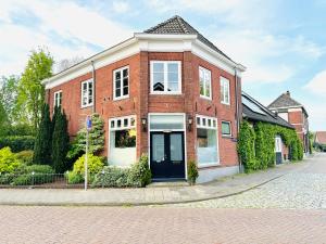 EttenB&B De Dorpshoeve的街上有红砖房子,有黑色的门
