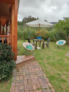 瓜斯卡Cabaña Los Linos的庭院配有桌椅和遮阳伞。