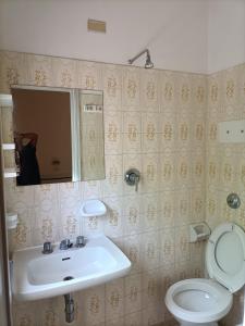 里米尼HOTEL ROSSINI的一间带水槽、卫生间和镜子的浴室