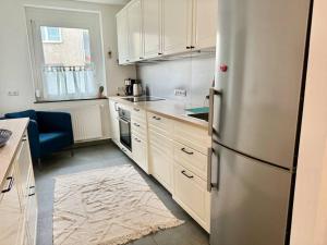 施韦夏特60 m2 Apartment near Airport - Free Parking的厨房配有白色橱柜和不锈钢冰箱