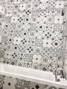 塞里斯Résidence Disneyland Place Toscane的浴室的墙壁上铺有黑白瓷砖。