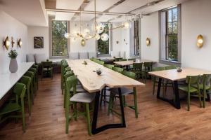 OronoHotel Ursa的餐厅设有木桌和绿色椅子