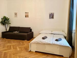 维也纳70 m2 Quiet & Calm Apartment with Free Parking的一间卧室配有一张床和一张沙发