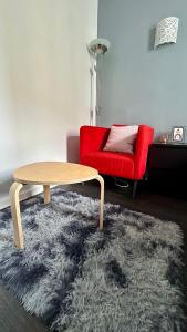 圣但尼Chambre Privée Kozy - Stade de France的客厅配有桌子和红色椅子