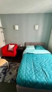 圣但尼Chambre Privée Kozy - Stade de France的一间卧室配有一张床和一张红色椅子