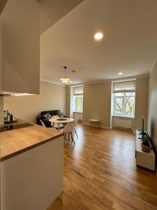 里加Pine cone cozy apartment的厨房以及带桌椅的起居室。