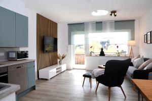 温特贝格Seeblick25 - Apartments - Balkony - WIFI - Great View - New & Modern的厨房以及带沙发和桌子的客厅。