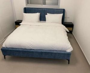 米茨佩·拉蒙וילה הנסיכה ‏‏的一张蓝色的床,上面有白色的床单和枕头
