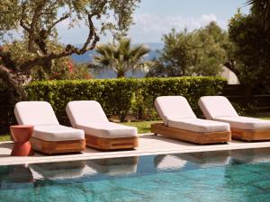 扎金索斯镇切洛豪华别墅酒店的一组躺椅,位于游泳池旁