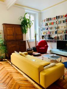都灵Apart Deluxe Casa Boffa-Costa的客厅配有黄色沙发和红色椅子