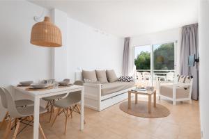 坎皮卡福特Bauló Mar Apartments的白色的客厅配有桌子和沙发
