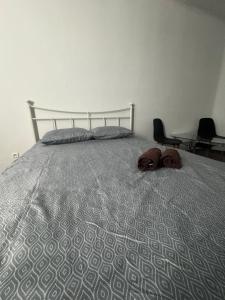 凯尔采Okno Na Rynek -Pokoje Paris -Parking的一张带灰色棉被和两个棕色物品的床