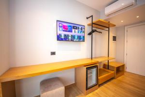 卡萨米尔Absolute Hotel Ksamil的客房设有书桌和墙上的电视。