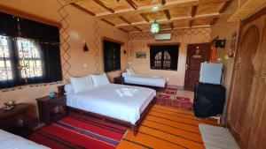 廷吉尔kasbah amlal的一间带两张床的卧室和一台电视
